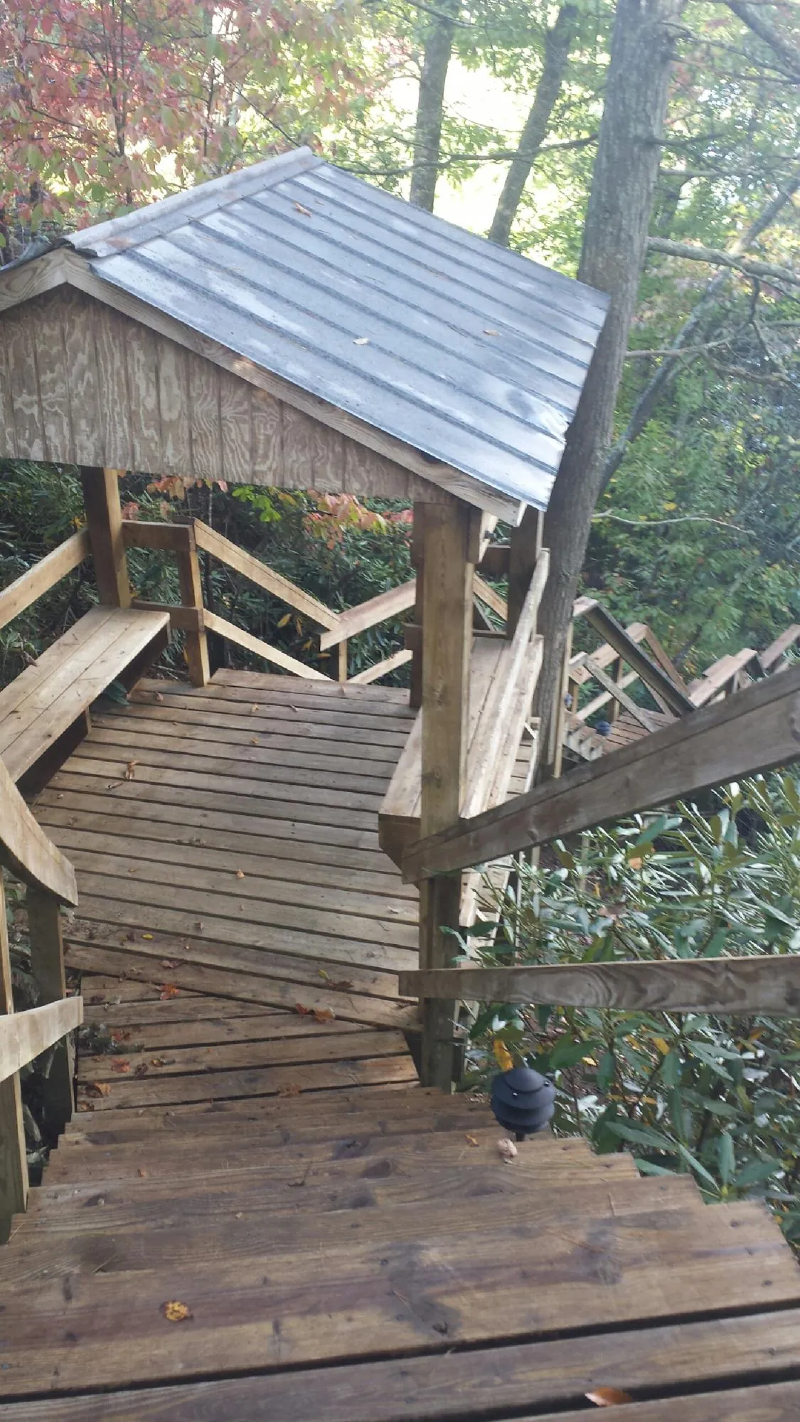 Metal roofed shelter over wooden steps on a wooded walkway — Skylight Repair & Installation work by our crew in Plainfield
